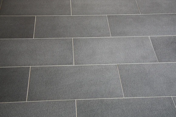 Graue Fliesen bilden einen Bodenbelag.